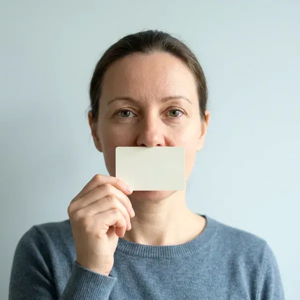 Woman holding a bank card flat under her nose to measure her PD with the phone camera