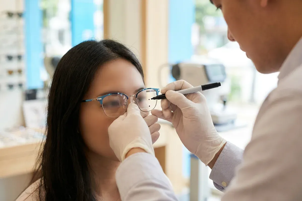 Optician marking the fitting height for progressive lenses on a frame